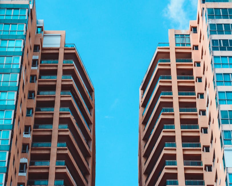 Contemporary high-rise buildings contrasted against a vivid blue sky